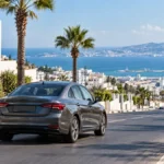 Voiture de location près d’une avenue de Tanger avec vue sur la mer au nord du Maroc.