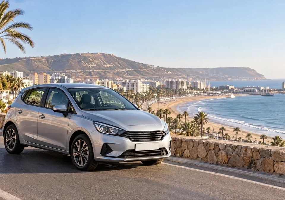 Voiture de location sur une route côtière de la région d’Agadir avec l’océan en arrière-plan.
