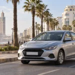 Voiture compacte de location dans une rue de Casablanca près d’immeubles et de palmiers.